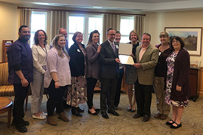 The Higham Senior Living Community holding the Purple Flag certificate.