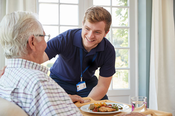 A male nurse and a resident at a senior living center for memory care.